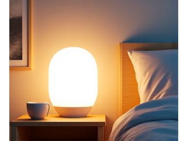 Lámpara de terapia de luz brillante en una mesita de noche, con el ambiente general de una rutina matutina saludable.