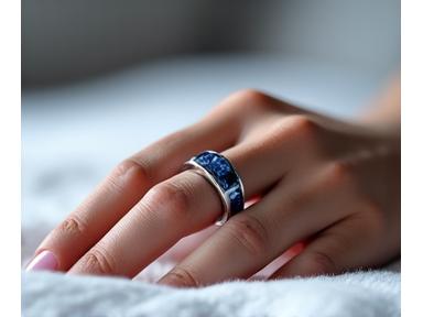 Un elegante Oura Ring Gen3 en el dedo índice de una persona adulta, con el foco en el diseño futurista del anillo.